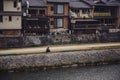 Beautiful shot of a person sitting on the side walking by the Kamogawa River in Kyoto, Japan