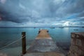 Beautiful shot of a pier leading to the ocean under the gloomy sky in Bonaire, Caribbean Royalty Free Stock Photo