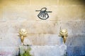 Beautiful shot of Pilgrim Fountain two gold lion taps and black scallop shell symbol on a stone wall