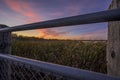 Beautiful shot of a railing near a field under a sunset sky in Grande Prairie of Alberta, Canada Royalty Free Stock Photo