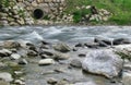 Beautiful shot of a river with a concrete drainpipe on the riverbank