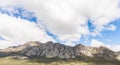 Beautiful shot of the rock formations in the green mountains under the bright cloudy sky Royalty Free Stock Photo