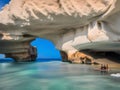 a beautiful shot of a rock in the sea with a beautiful white arch