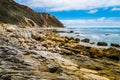 Beautiful shot of rocks near the sea under a blue cloudy sky in California Royalty Free Stock Photo