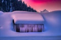 Beautiful shot of the roof and windows of a house fully covered with snow and icicles in winter