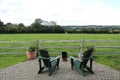 Beautiful shot of a rural territory with two chairs near a wooden fence