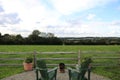 Beautiful shot of a rural territory with two chairs near a wooden fence