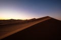 Beautiful shot of sand dunes under a purple and blue sky Royalty Free Stock Photo