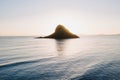 Beautiful shot of a silhouette of a small island in the center of the open sea