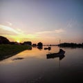 Beautiful shot of silhouettes of boats parked in a lake during the sunset