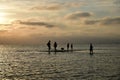 Beautiful shot of silhouettes of people hanging around on a wooden dock over a pier at sunset Royalty Free Stock Photo