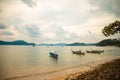 Beautiful shot of small boats in the sea next to the shore on a cloudy day Royalty Free Stock Photo