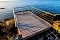 Beautiful shot of a sunrise on a pier over the hill and an ocean Royalty Free Stock Photo