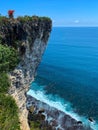 Beautiful shot of a tall cliff by the coastline with clear blue sea Royalty Free Stock Photo