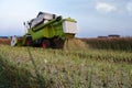 Beautiful shot of a tractor reaping the wheat spikes in the field during daytime Royalty Free Stock Photo