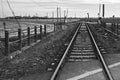 Beautiful shot of train tracks in the middle of an empty field in black and white Royalty Free Stock Photo