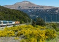 Beautiful shot of a travelling train with a high mountain and a clear blue sky in the background Royalty Free Stock Photo