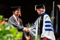 Beautiful shot of two men happily shaking hands in the UMass graduation event in Amherst MA, USA