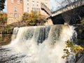 Beautiful shot of a waterfall under the bridge in front of apartment buildings during daytime Royalty Free Stock Photo