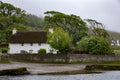 Beautiful shot of a white cottage in a valley at Ogmore Castle in South Wales on a cloudy day Royalty Free Stock Photo