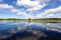 Beautiful shot of white fluffy clouds reflected on a lake on a sunny day Royalty Free Stock Photo