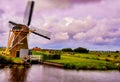 Beautiful shot of a windmill near the lake under a cloudy sky in Holland Royalty Free Stock Photo