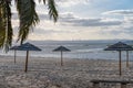 Beautiful shot of wooden beach umbrellas on an empty sandy beach under dusk cloudy sky Royalty Free Stock Photo