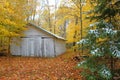 Beautiful shot of a wooden house surrounded by autumn trees in the forest Royalty Free Stock Photo