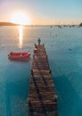 Beautiful shot of a wooden pier and a red boat at Santa Guilia beach in Corsica, France Royalty Free Stock Photo