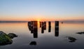 Beautiful shot of worn-out pier pillars on a body of water during sunset. Perfect for a wallpaper Royalty Free Stock Photo