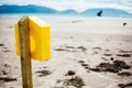 Beautiful shot of a yellow birdhouse attached to a wooden column in the shore Royalty Free Stock Photo