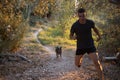 Beautiful shot of a young male running in nature with his dog Royalty Free Stock Photo