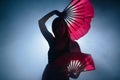 Beautiful silhouette of a girl elegantly dancing in smoke and fog.