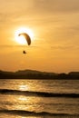 Beautiful Silhouette of paraglider flying in the sky of sunset on the beach. Royalty Free Stock Photo