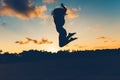 Beautiful silhouette portrait of summer girl jumping on white sand in exotic island at sunset. Serenity, relaxation, mindfulness,