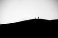 Beautiful silhouette shot of people on a hill in grayscale