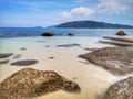 The beautiful silky smooth water waves and rocks on the sea shore. Royalty Free Stock Photo