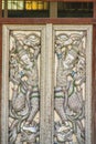 Beautiful silver door leaves with carved silver angels image. Thai style patterned on door leaves made of silver and glass with an