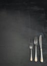 Beautiful silver fork, fork for desserts and a knife on a black background Royalty Free Stock Photo