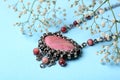 Beautiful silver necklace with rhodonite and tourmaline gemstones on blue background