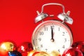 Beautiful silver vintage alarm clock and set of red, blue and golden Christmas balls on a bright red background Royalty Free Stock Photo