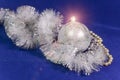 Beautiful silvery New Year`s ball, brilliant tinsel and silver cones on a blue background - New Year`s composition, a card Royalty Free Stock Photo