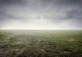Beautiful simple gravel and grass background with mist and dramatic clouds and sky Royalty Free Stock Photo