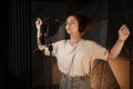 Beautiful singer girl in headphones sensually singing working on new music album in recording studio Royalty Free Stock Photo