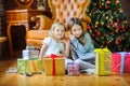 Beautiful sisters sit on the floor near the Christmas tree Royalty Free Stock Photo