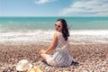 Beautiful sitting woman enjoying the idyllic scene of the sun, sea and beach. Beautyful beach in Antalya. Royalty Free Stock Photo