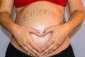 Beautiful six month pregnant woman showing her tummy drawing a heart on it with her hands. June 25, 2019. Madrid. Spain. Royalty Free Stock Photo