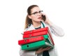 Attractive caucasian brunette confident female doctor standing in office with binders in her hands talking on phone on Royalty Free Stock Photo