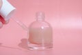 beautiful skin flat lay care pink serum liquid dropper minimal pink background