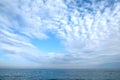 Beautiful sky landscape with white flying clouds extending over the skyline line of the ocean surface Royalty Free Stock Photo